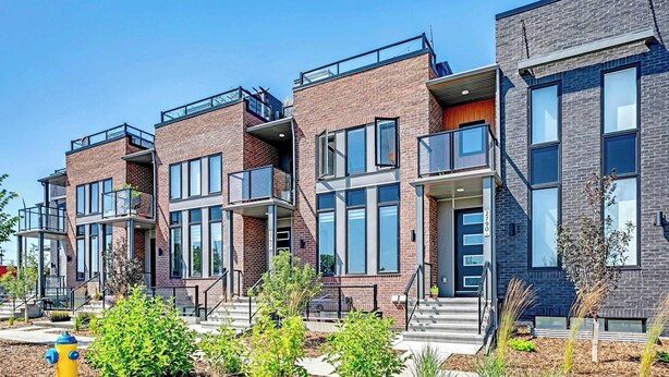 A row of modern brick townhouses with balconies, large windows, and a fire hydrant in the foreground. - Blatchford - 2 Queen Beds - W/D to NAIT (Northwest)