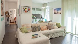 A living room with a sofa, pillows, and a magazine on the coffee table.