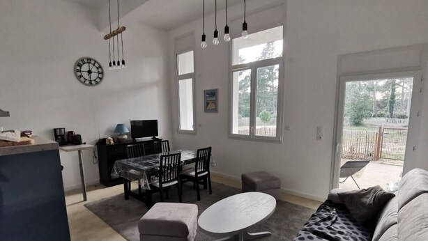 A spacious living area with a dining table, a sofa, and a TV. - Welcome at Sylvie's residence (La Tranche-sur-Mer)