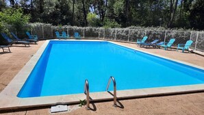 A rectangular swimming pool with a tiled edge, surrounded by a fence and several lounge chairs. - Welcome at Sylvie's residence (La Tranche-sur-Mer)