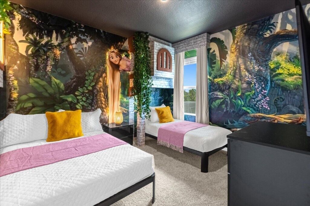 A room with two beds, a window, and a mural of a forest scene.
