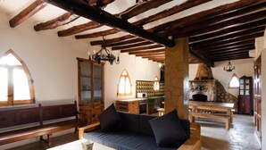 A rustic interior with exposed wooden beams, a stone fireplace, and a cozy seating area. - Mas d´en Tarres by Interhome (El Catllar)