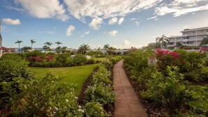 A pathway through a landscaped garden with a clear sky and a sign indicating no smoking. - Sublime Stay - Royal Retreats at Maho Beach (Lowlands)