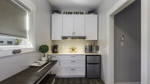 A compact kitchen with white cabinets, a coffee bar, and a small refrigerator. - SweetDove Stays-  Suite; w/ Stocked Lake, Secure Parking (Rains County)