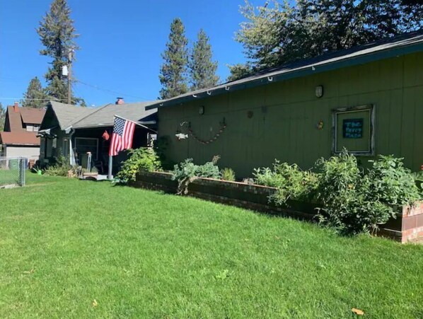Welcome to The Ferry Place, where a charming porch invites relaxation amidst a beautifully manicured lawn and lush surroundings.