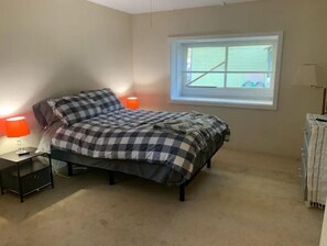 Cozy bedroom with a single bed, nightstand, and window with blinds.