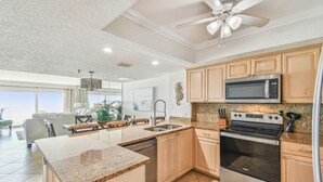 Una cocina moderna con encimeras de granito, electrodomésticos de acero inoxidable y armarios de madera.