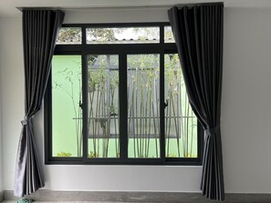 Enjoy a serene view of lush bamboo plants from the large window.