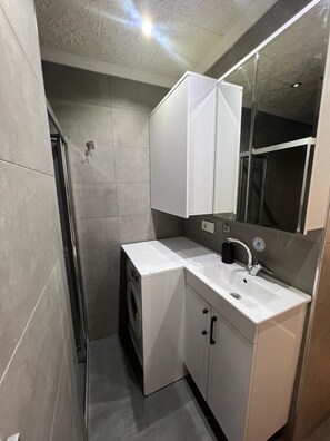 Douche, douche à « effet pluie », sèche-cheveux, chaussons