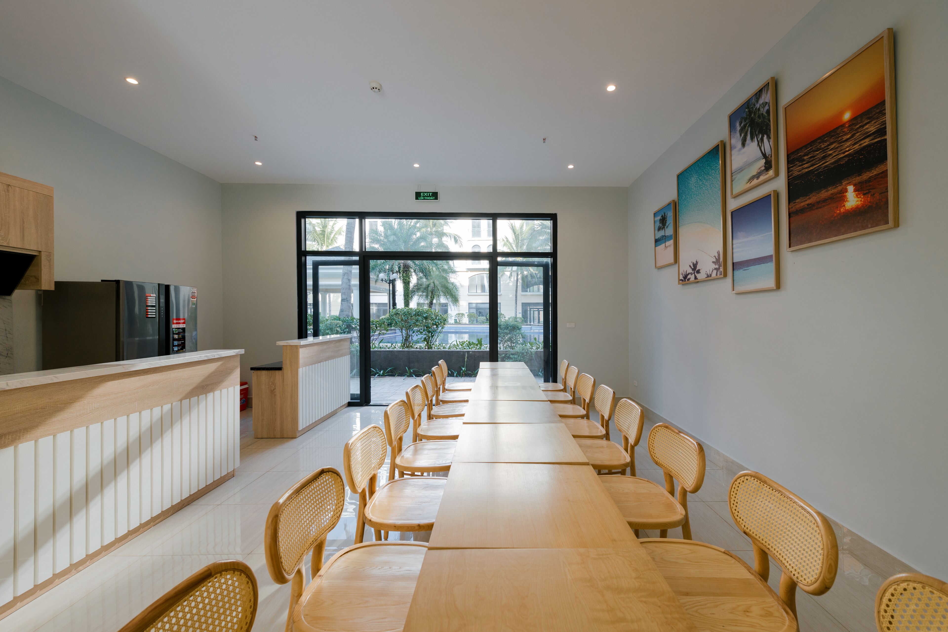 A long dining table with chairs, a reception desk, and framed pictures on the wall.
