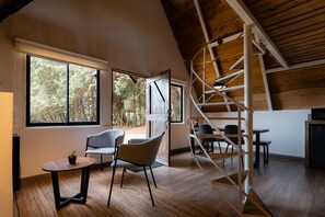 A modern interior with a wooden ceiling, large windows, a staircase, and a dining area. - EyB Chalets (Ángeles)