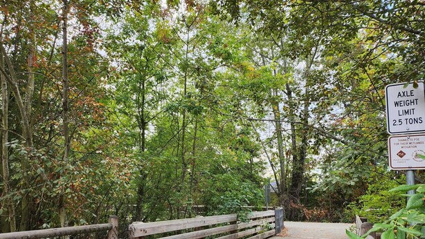 Un pont en bois sur lequel est affiché un panneau indiquant une limite de poids de 2,5 tonnes.