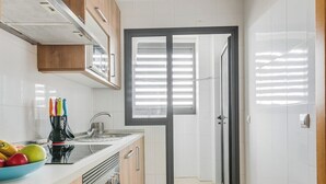A modern kitchen with wooden cabinets, a stainless steel sink, and a built-in oven.