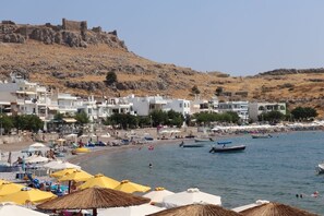 A coastal town with white buildings, a beach, and boats.