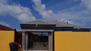 Un bâtiment doté d’un toit recouvert de tuiles et d’un mur extérieur jaune.