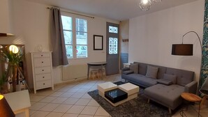 A living room with a sofa, coffee table, and a small table with a lamp.