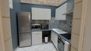 A compact kitchen with a stainless steel refrigerator, a microwave, a dishwasher, and a sink.