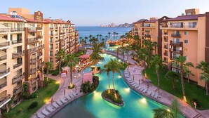 Een resort met meerdere gebouwen, een centraal zwembad en uitzicht op zee.
