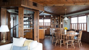 Ein rustikales Interieur mit einer Holztreppe, einem Essbereich mit Holzkästen und einer Küche mit Holzsäcken.