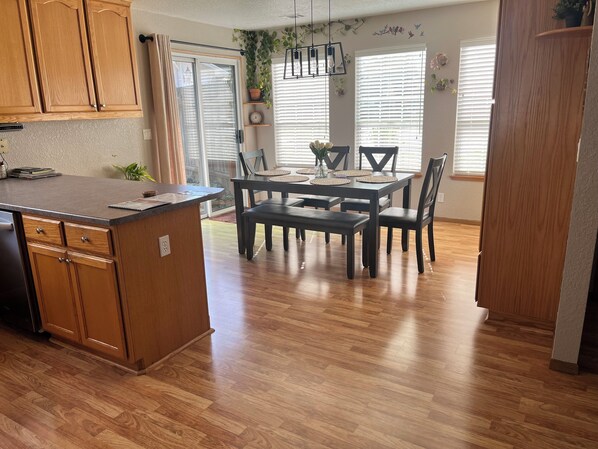 A kitchen with wooden cabinets, a dining table with chairs, and a built-in island.