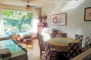 Un comedor con una mesa y sillas, un ventilador de techo y vistas al exterior.