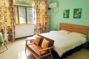A room with a bed, a wooden bench, a chair, a window with curtains, and wall-mounted air conditioning. - Nanxi Longevity Flower Farmer Stay Inn (Yongjia)