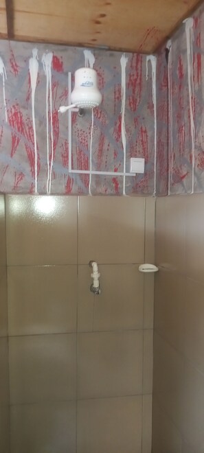 Bathroom features a tiled floor and walls, a wall-mounted faucet, and a ceiling.