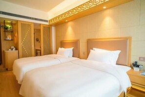 Une chambre d’hôtel avec deux lits, une tête de lit en bois, une table de chevet avec une lampe et un miroir.