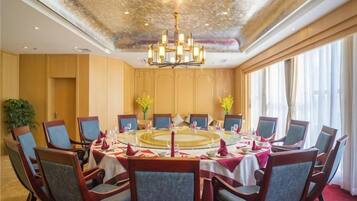 A conference room with a round table, chairs, and a chandelier.