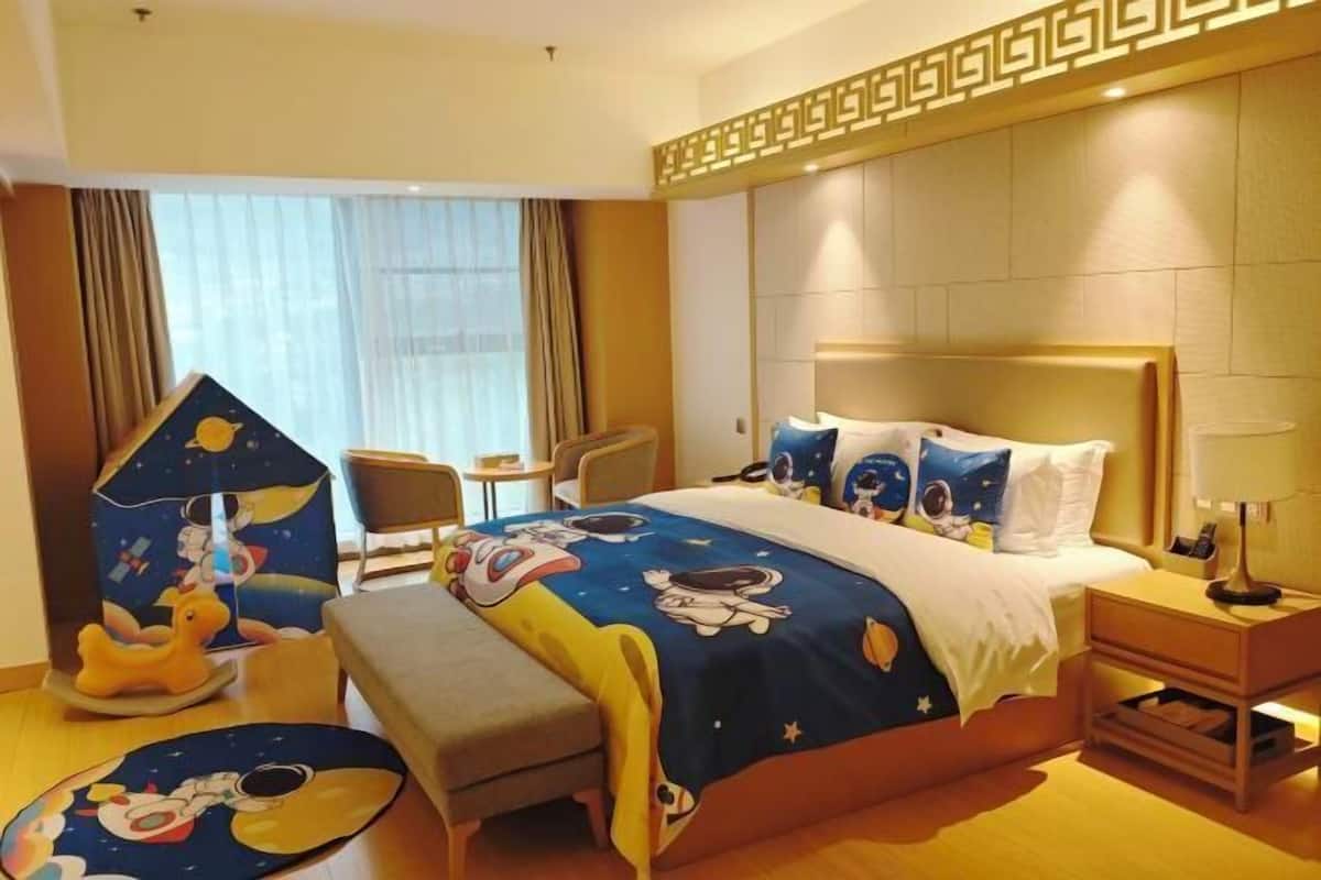 Una habitación de hotel con cama, mesitas de noche, escritorio y una silla.