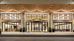 L’entrée d’un hôtel, dotée d’une porte tournante, de grandes fenêtres et d’un design de plafond moderne.