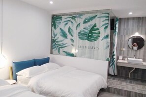 A bedroom with a bed, a blue pillow, a wall with a green leaf pattern, and a bathroom with a mirror and sink. - July 3rd (Fenghuang County)