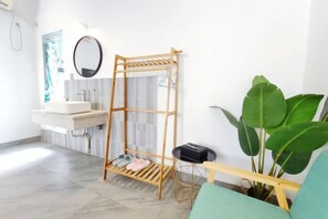 A bathroom with a wooden drying rack, a sink, a mirror, a potted plant, and a bench. - July 3rd (Fenghuang County)
