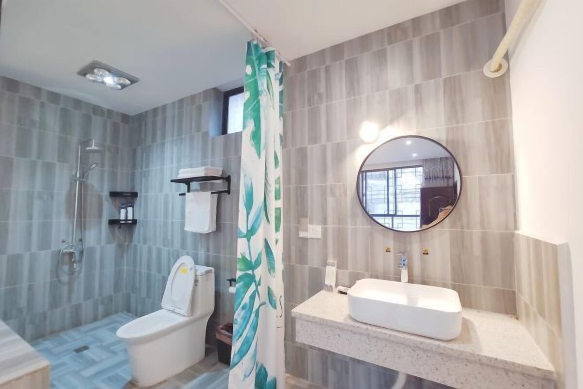 A modern bathroom with a toilet, shower, and sink.