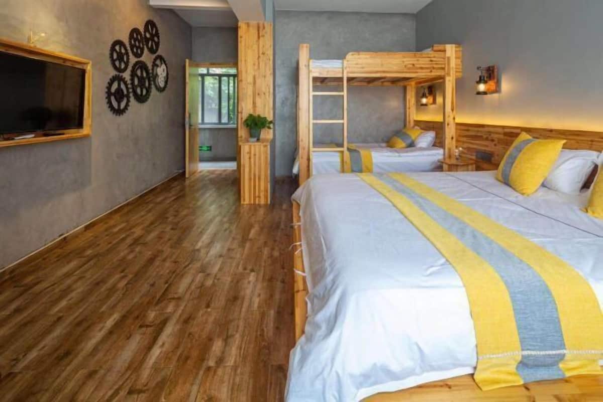 Ein Zimmer mit einem Etagenbett, einem Schreibtisch und einem Fenster.
