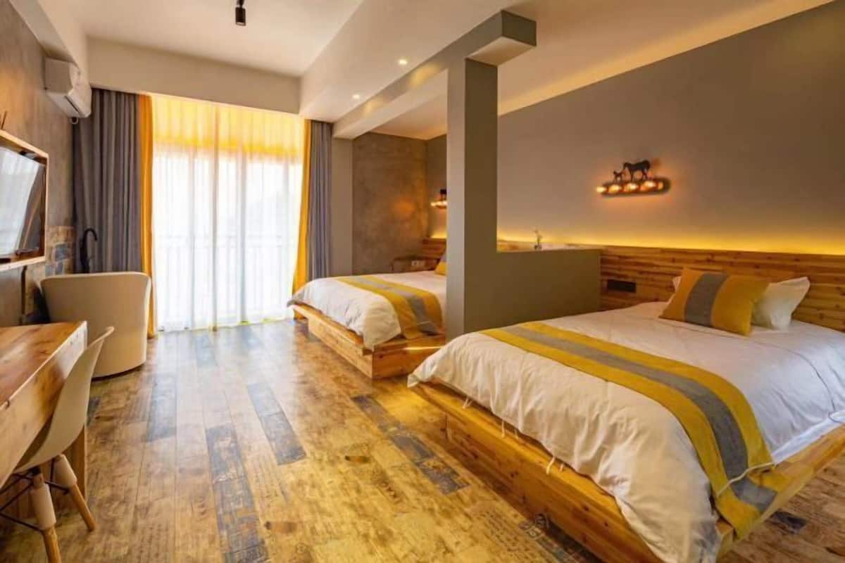 Ein Hotelzimmer mit zwei Betten, einem Schreibtisch und einem Stuhl.