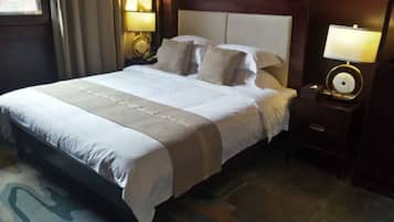 A hotel room with a large bed, two bedside tables with lamps, and a headboard.