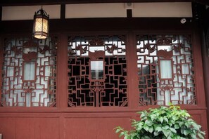 A traditional building facade with wooden lattice windows and a hanging lantern. - Xinglong Street Courtyard Hostel (Chongqing)
