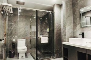 A modern bathroom with a glass-enclosed shower, a white toilet, and a large mirror above a white sink. - Gutang Hotel (Yuyao)