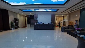 Un hall espacioso con una recepción, un tragaluz grande y un diseño de interiores moderno.