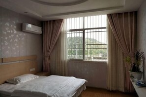 A bedroom with a bed, window, curtains, and a potted plant. - Xiagu Renjia Hostel (Qianshan)