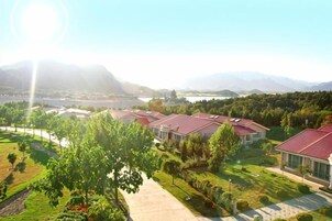 Zona residencial con casas, un sendero y una masa de agua al fondo.
