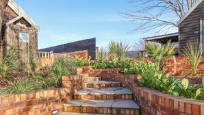 A brick staircase leading up to a wooden building with a sign that reads "Sunset Retreat." - Sunset Retreat (Scarborough)