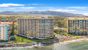 Un hôtel de grande hauteur doté de nombreux balcons, d’un espace piscine et offrant une vue sur l’océan et les montagnes.