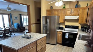 A modern kitchen with wooden cabinets, stainless steel appliances, and a granite countertop.