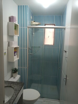 Een douche, handdoeken, zeep, toiletpapier