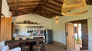 A rustic kitchen with a wooden ceiling, a hanging basket light, and a stone floor. - CASA MORANESI (Caucasia)