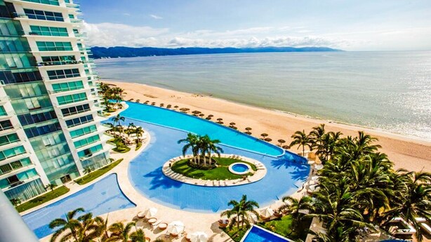 A resort with a large swimming pool, a beach, and a high-rise building. - Península T3 1A Luxurious Ocean View Getaway! (Puerto Vallarta)
