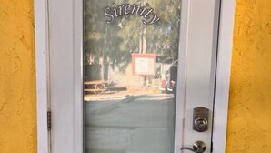 En dörr med en panel av frostat glas där ordet ”Serenity” syns.