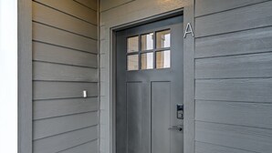 A dark gray door with a window and a keypad lock. - Med Center Luxury stay with free parking!  (Houston)